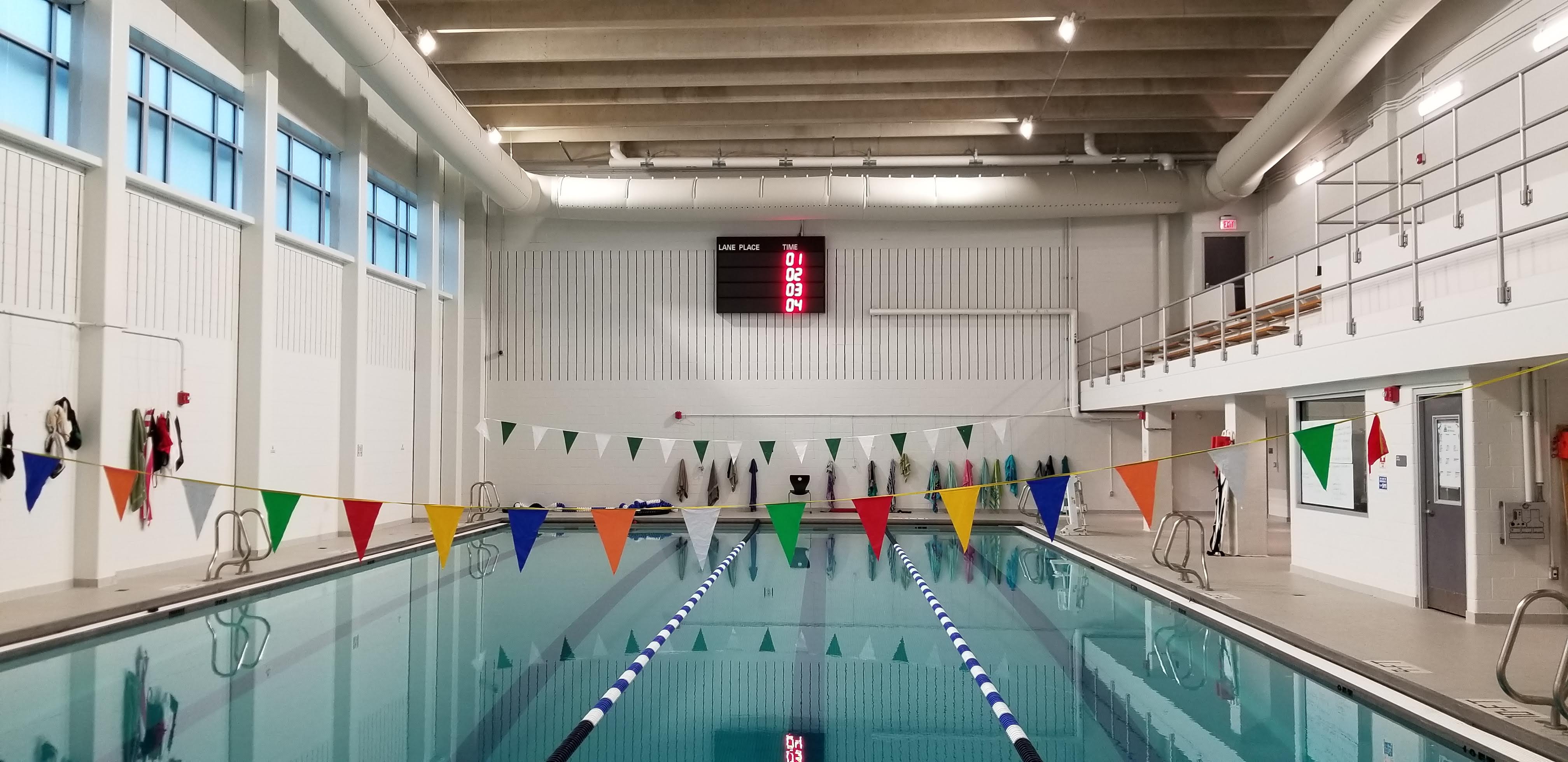 an indoor swimming pool with flags hanging from the ceiling