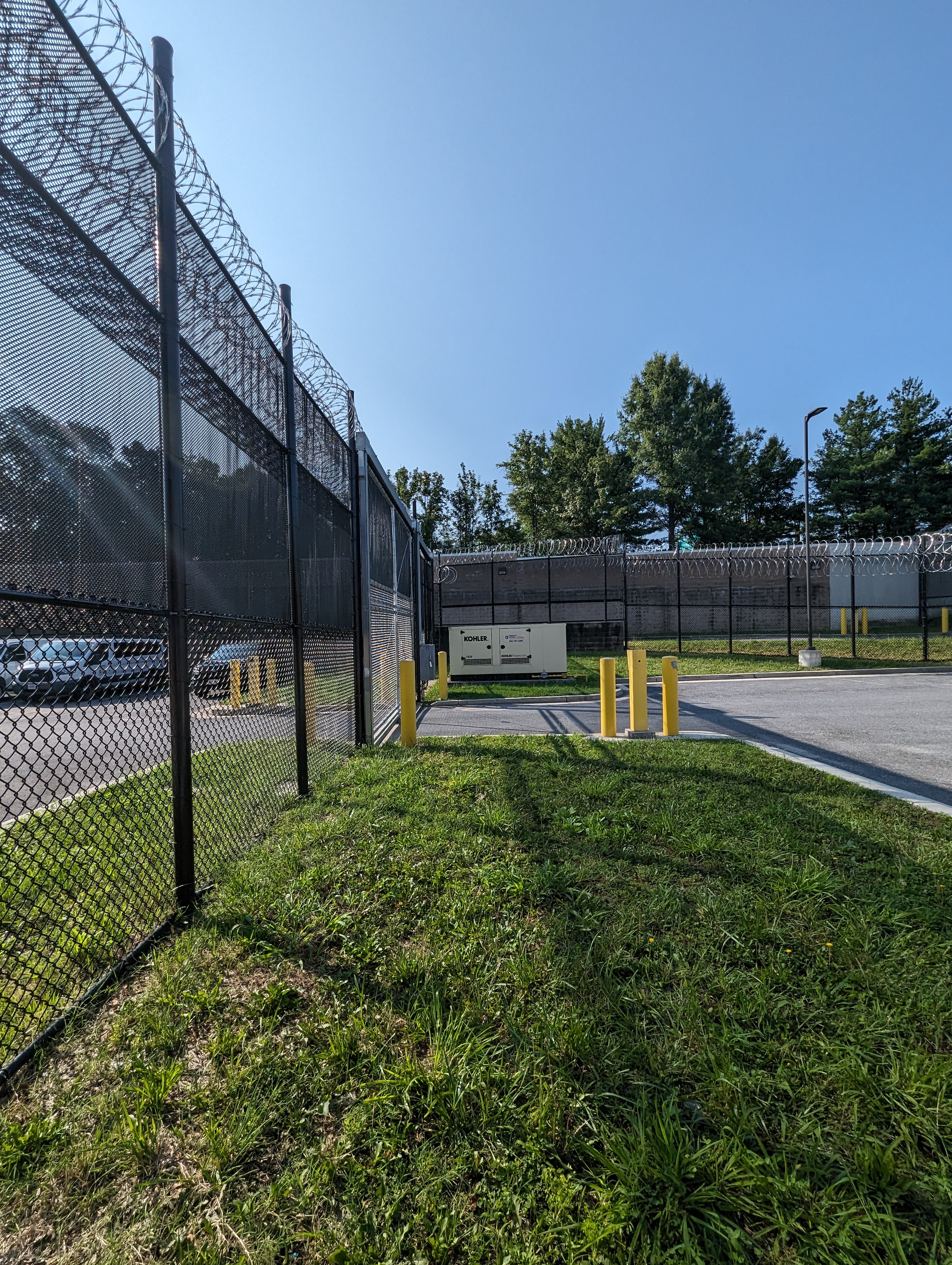 a fenced in parking lot next to a parking lot