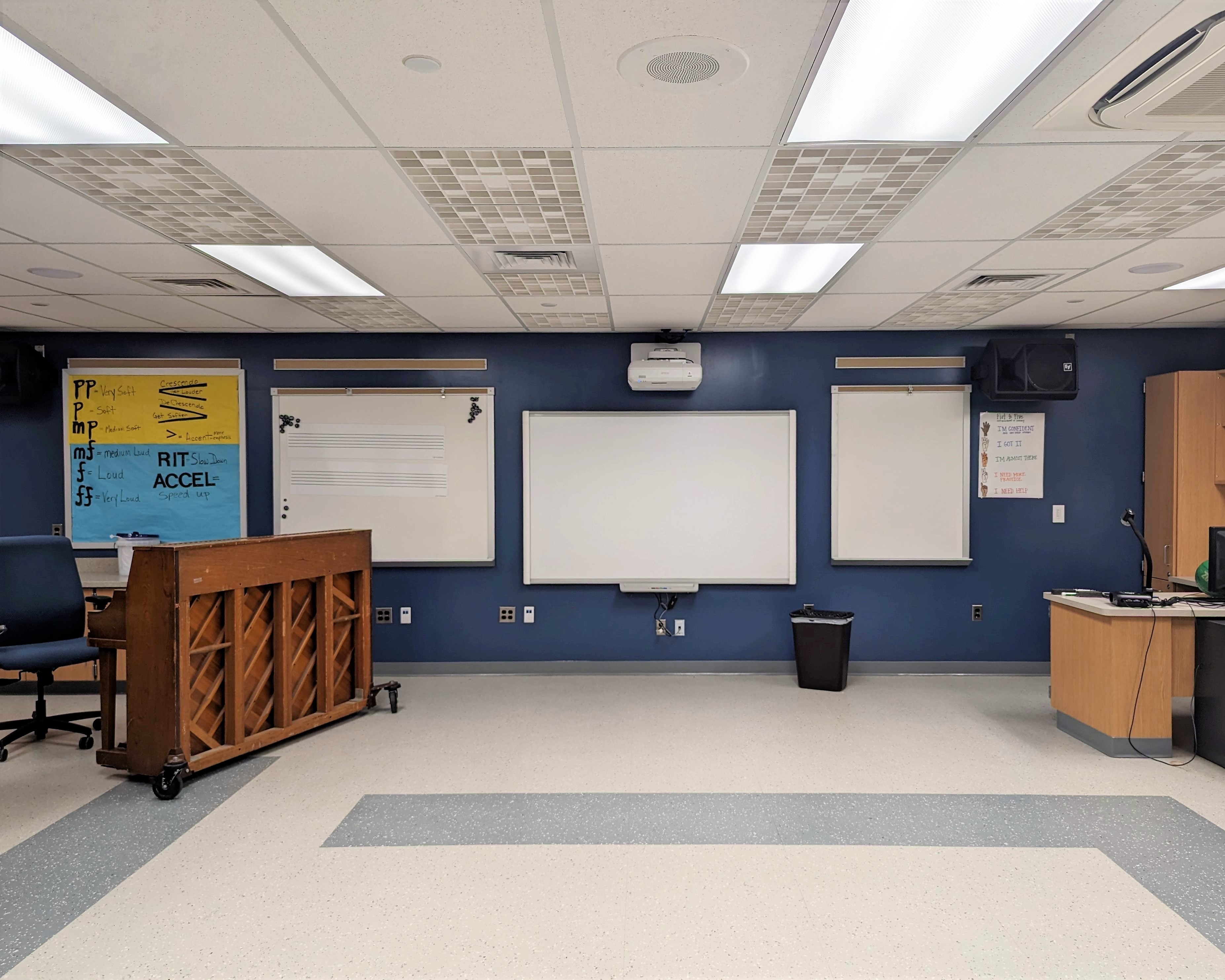 a large room with a projector screen and chairs