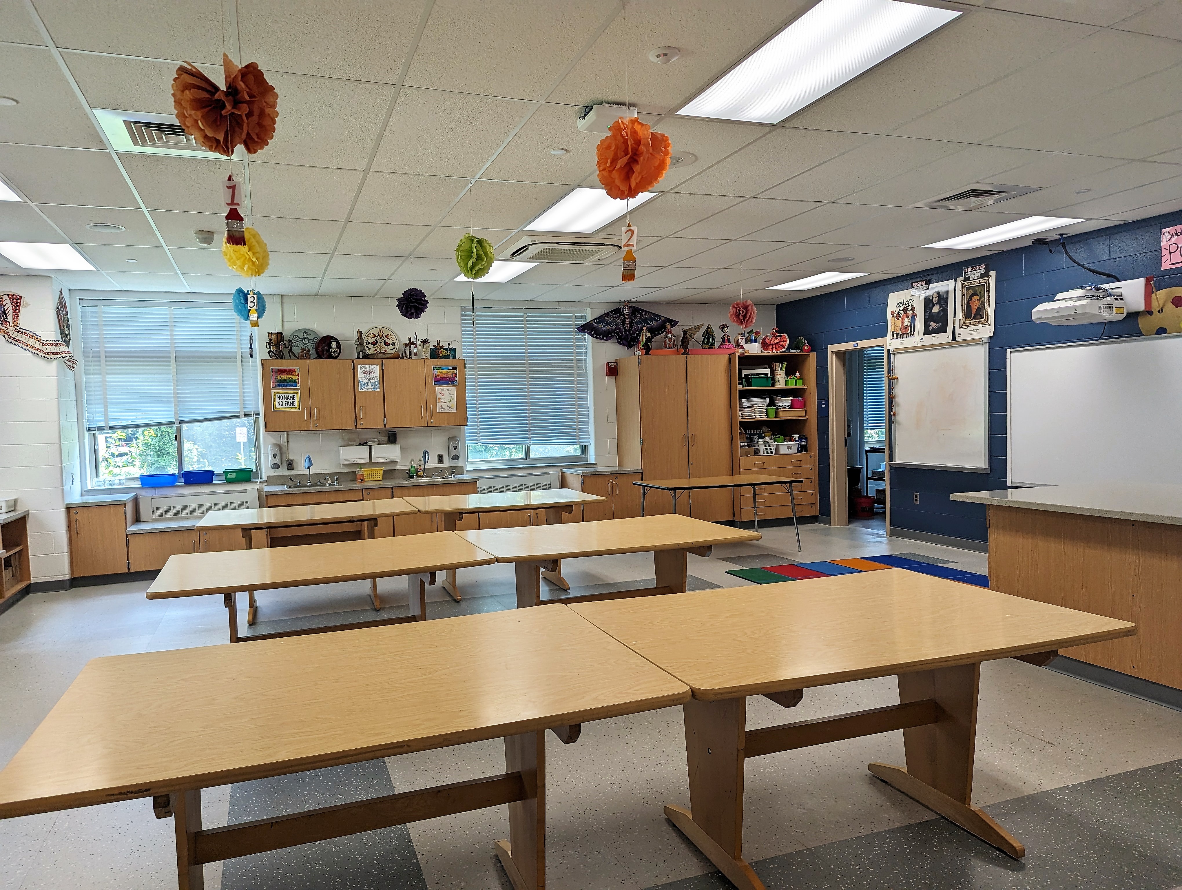 a classroom with tables and a whiteboard