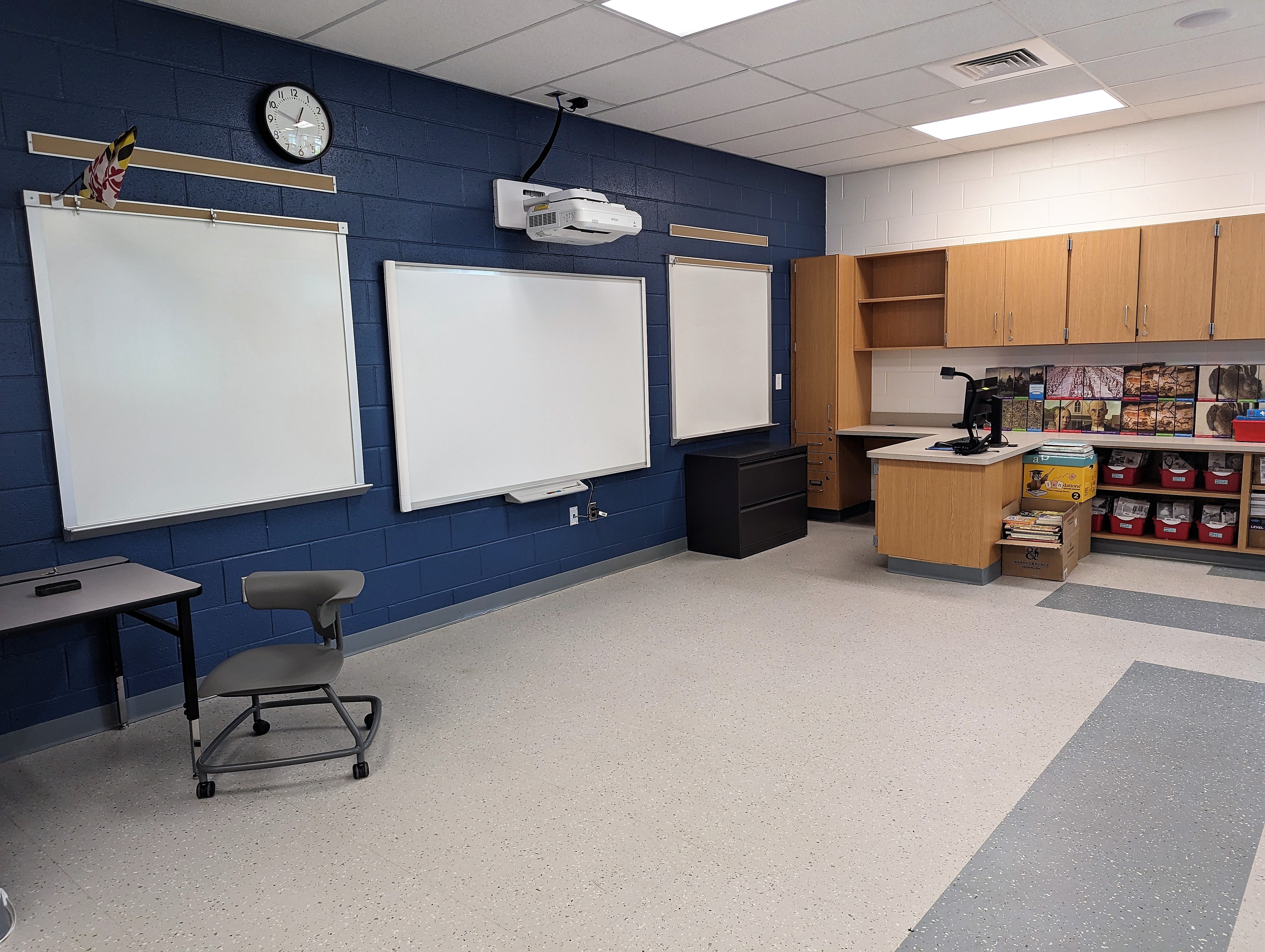 a classroom with a whiteboard, desks, and chairs