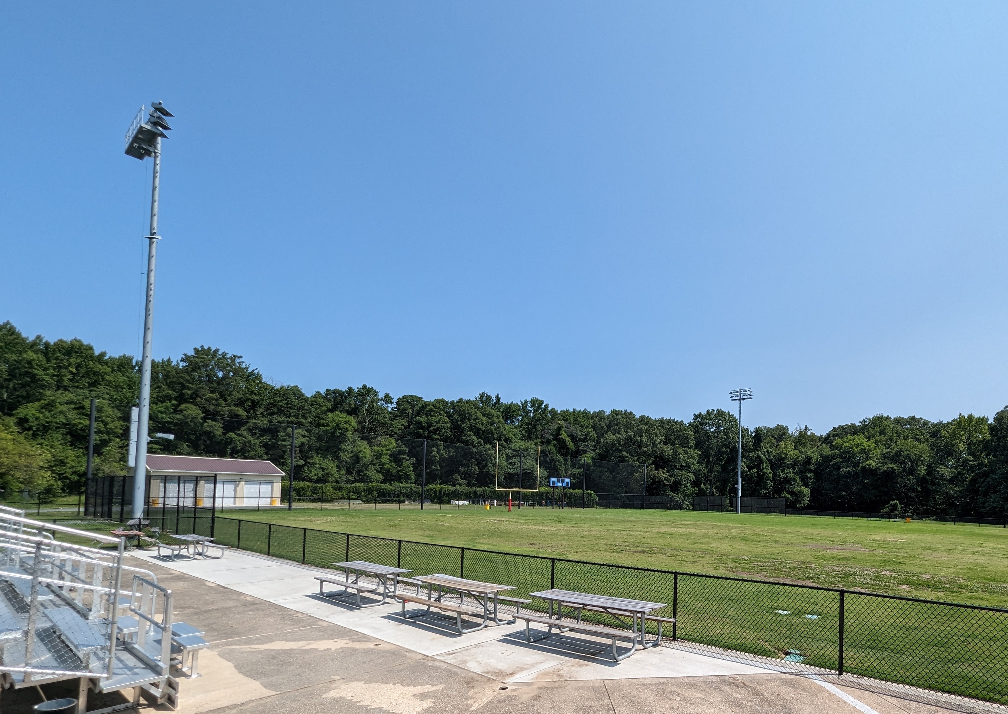 a baseball field with benches and a fence