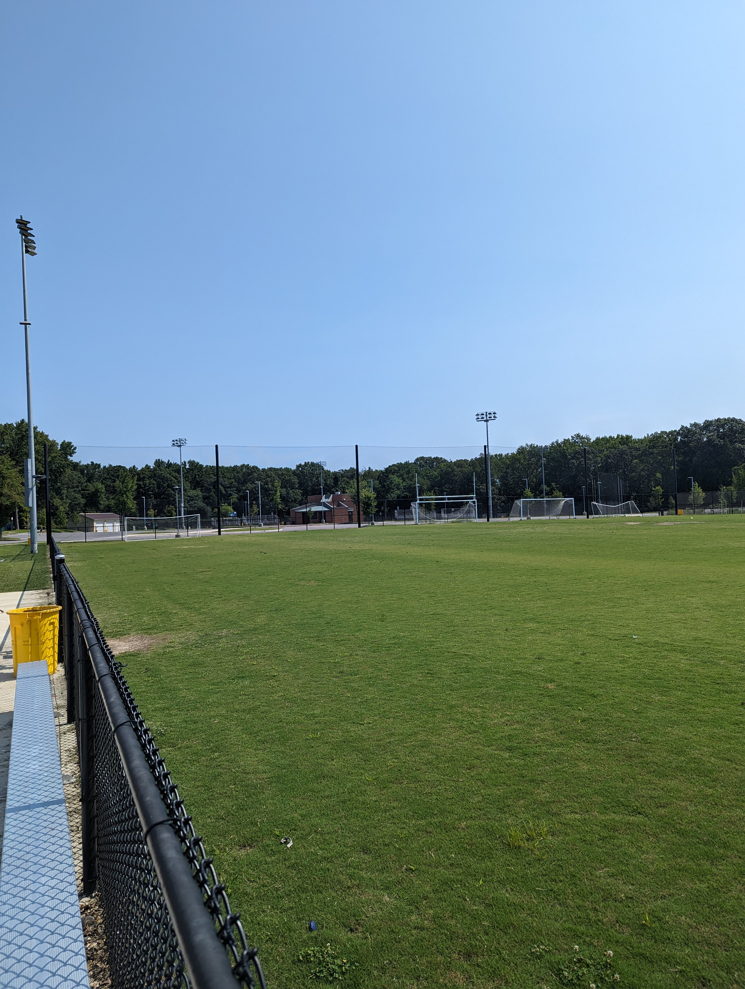 a baseball field with a fence in the foreground