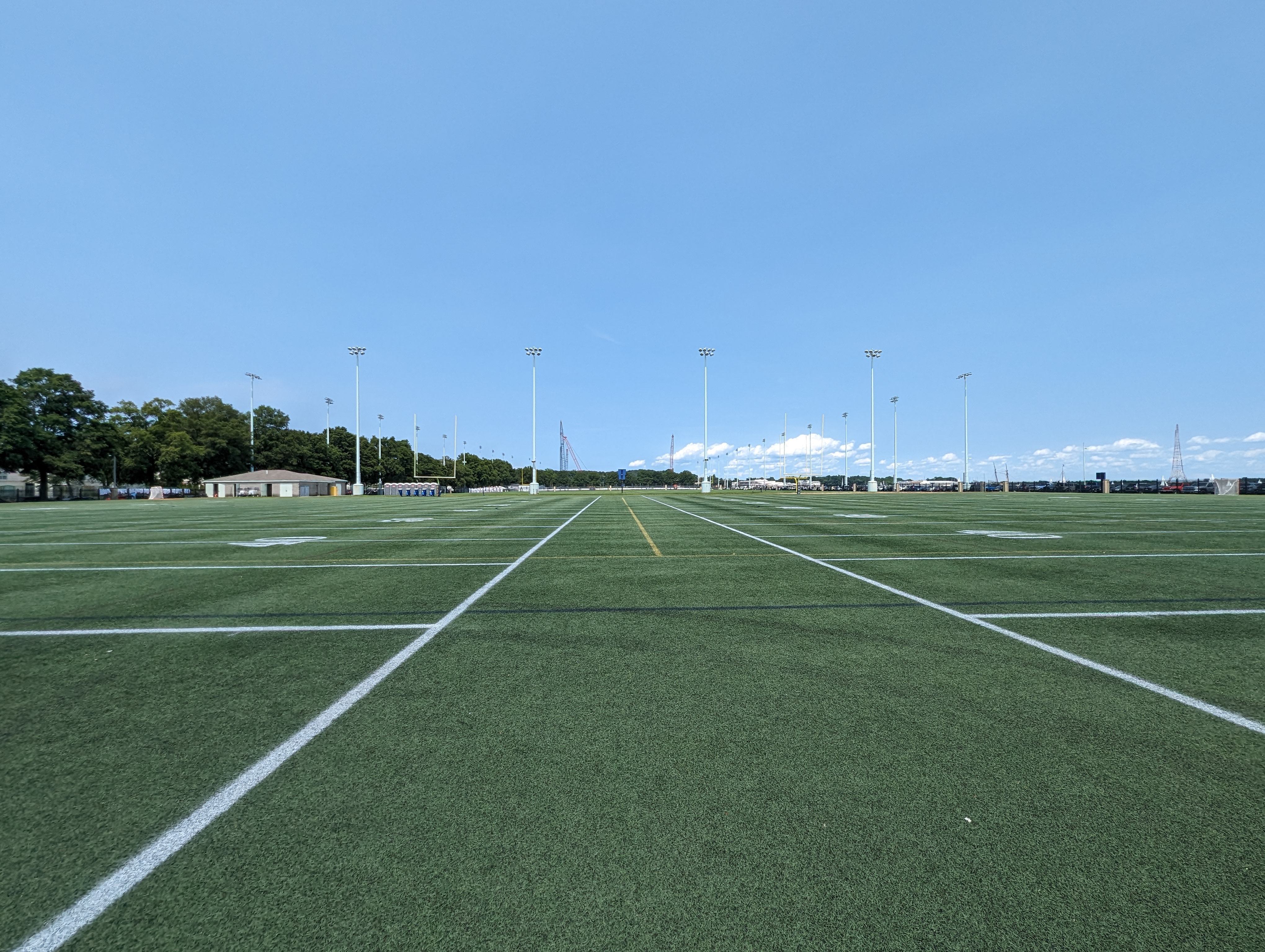 an empty soccer field with a blue sky in the background