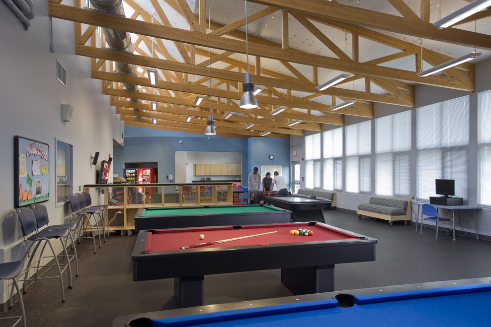 a pool table in a large room with lots of windows