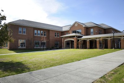 a large brick building sitting on top of a lush green field