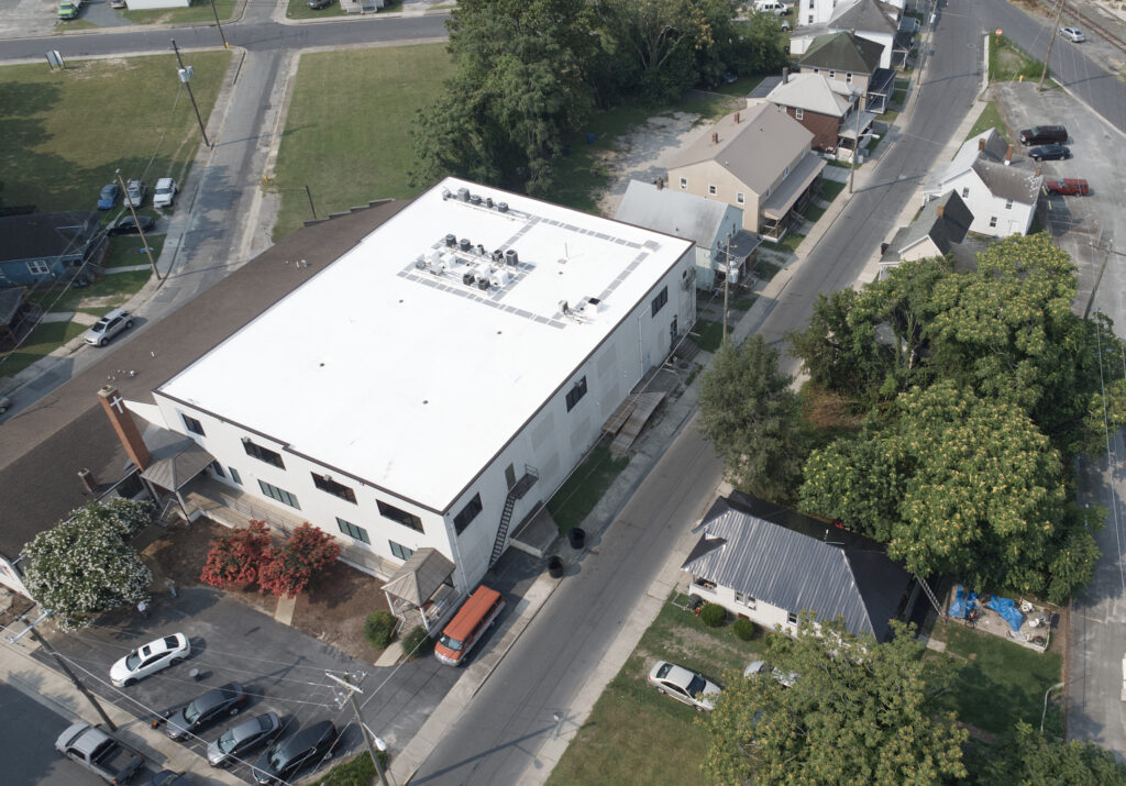 an aerial view of a building with cars parked in front of it